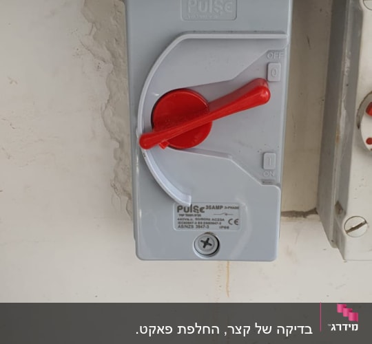 מתג חשמלי אפור עם ידית אדומה